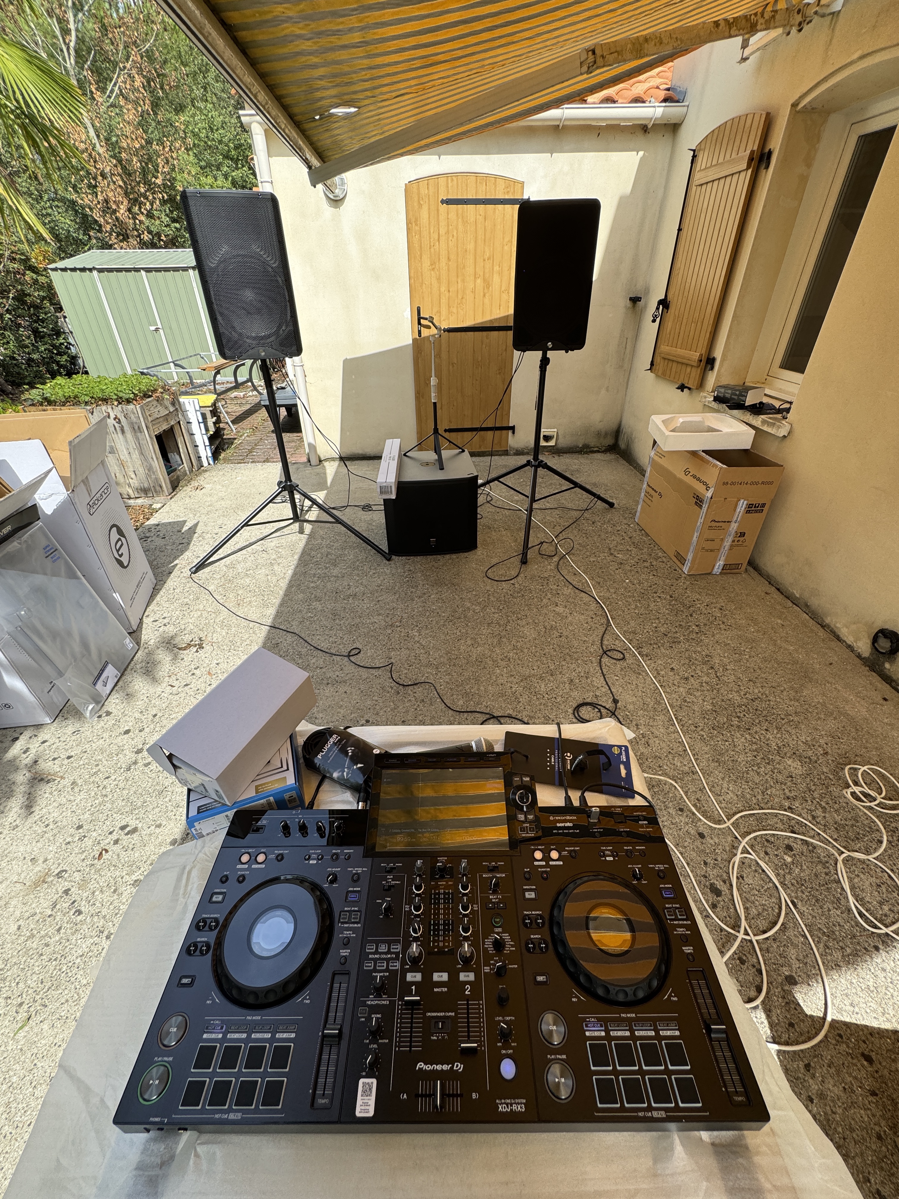 Platine XDJ-RX3, enceintes sur pieds et caisson installés en extérieur